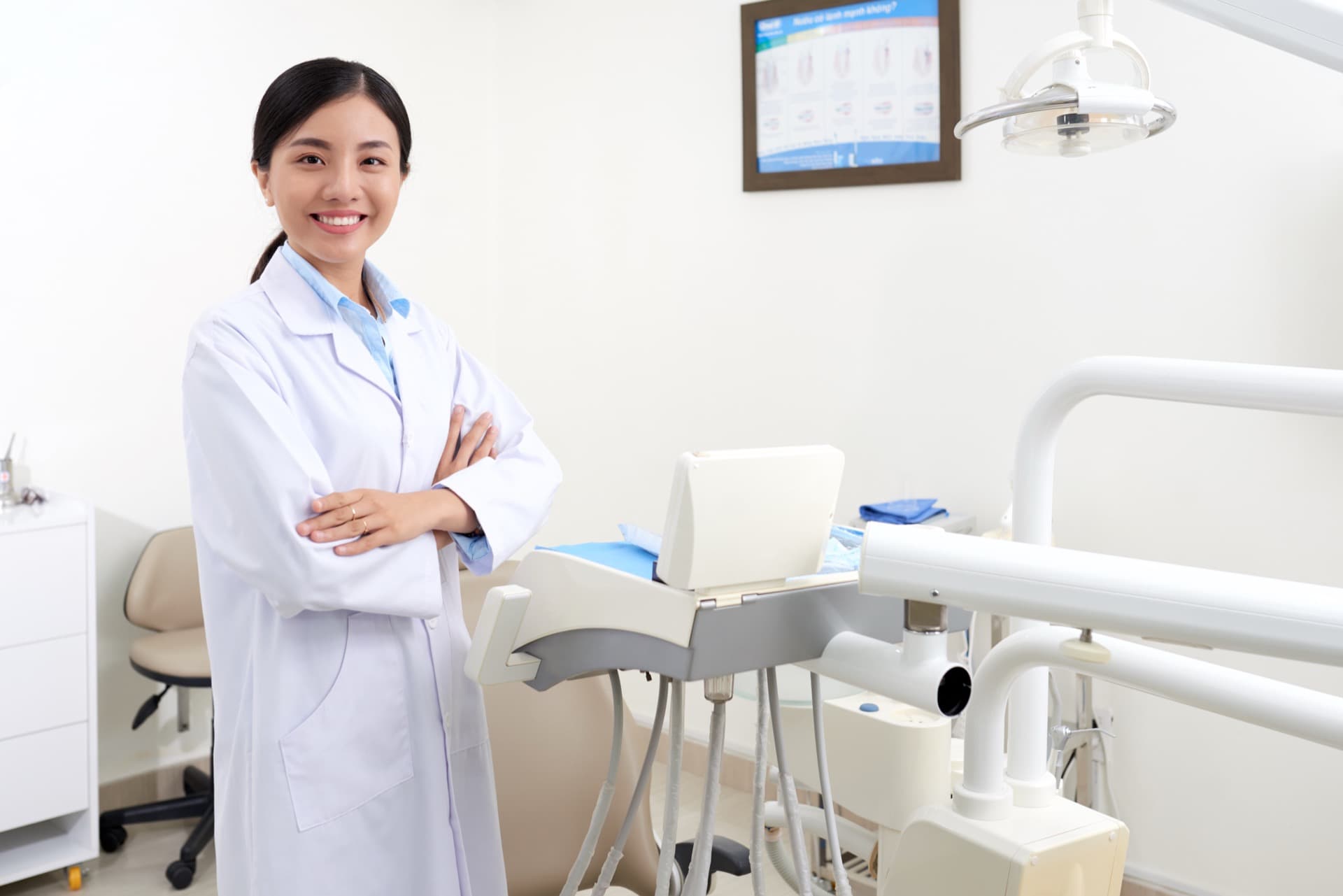 Asian woman dentist standing in a bright treatment room