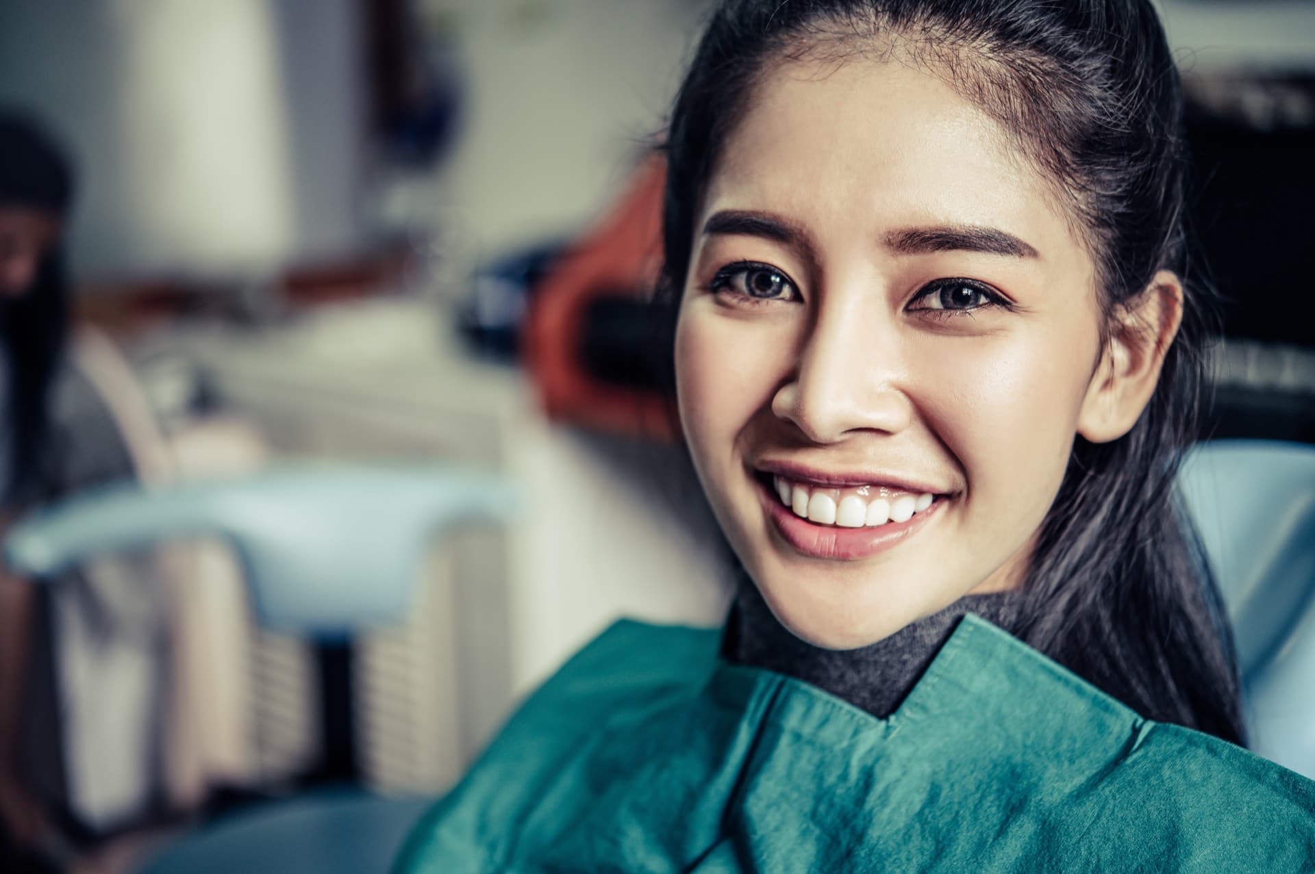 Smiling patient seated in a dental chair after an examination