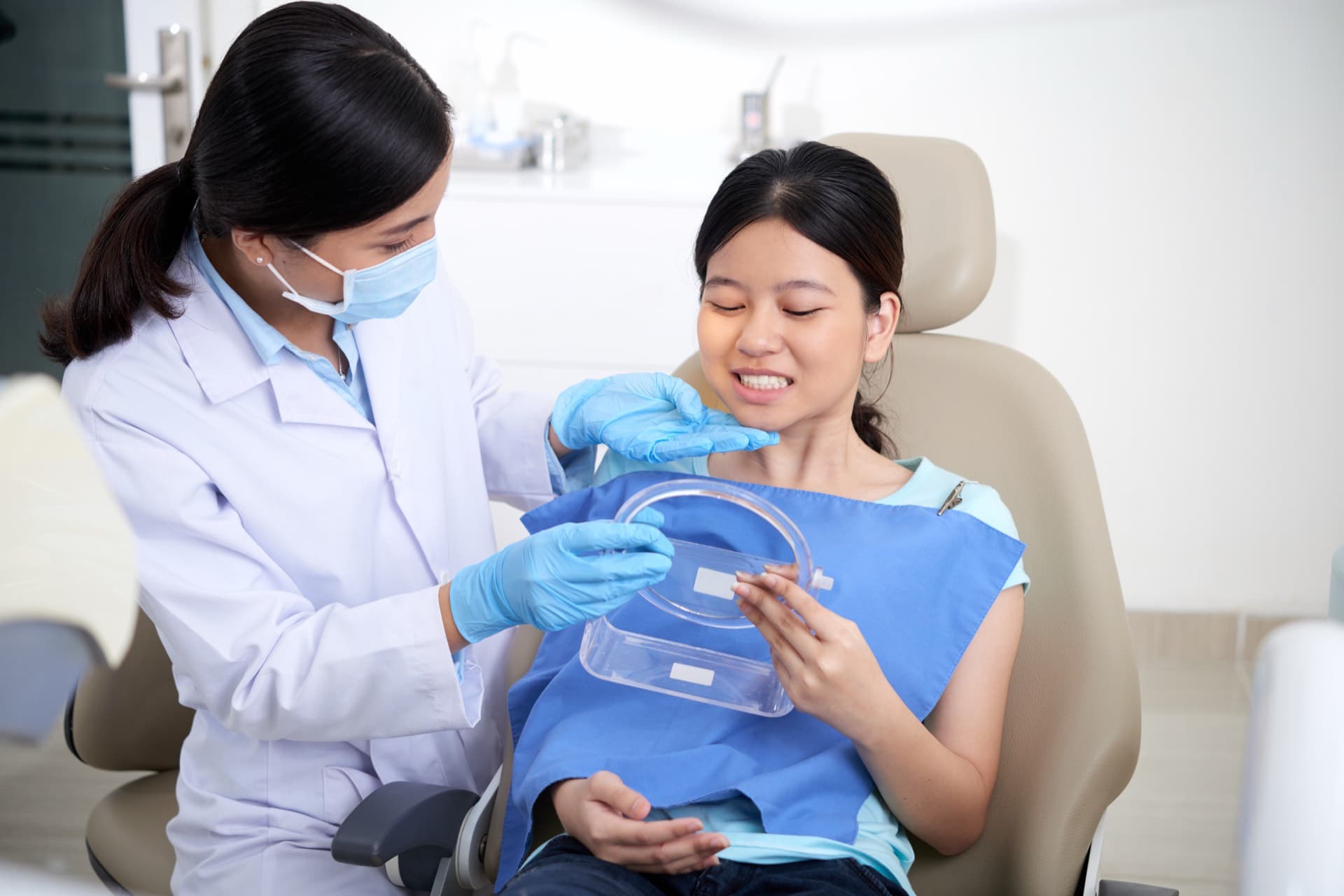 Dentist handing a seated patient a small clear case